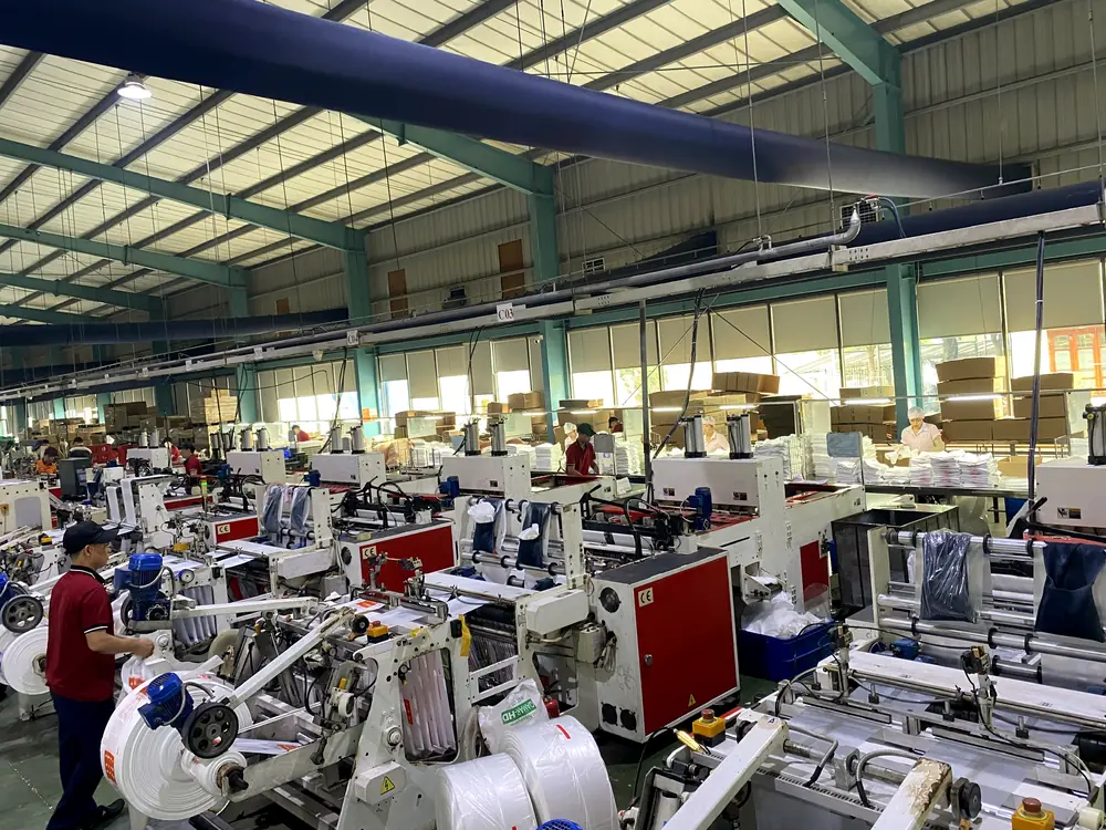 Operator at a cutting and sealing machine in the bag-making hall