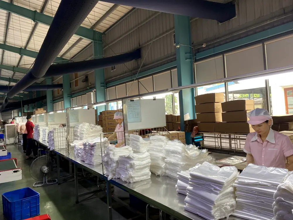 Workers counting and packing finished bags at the packing tables
